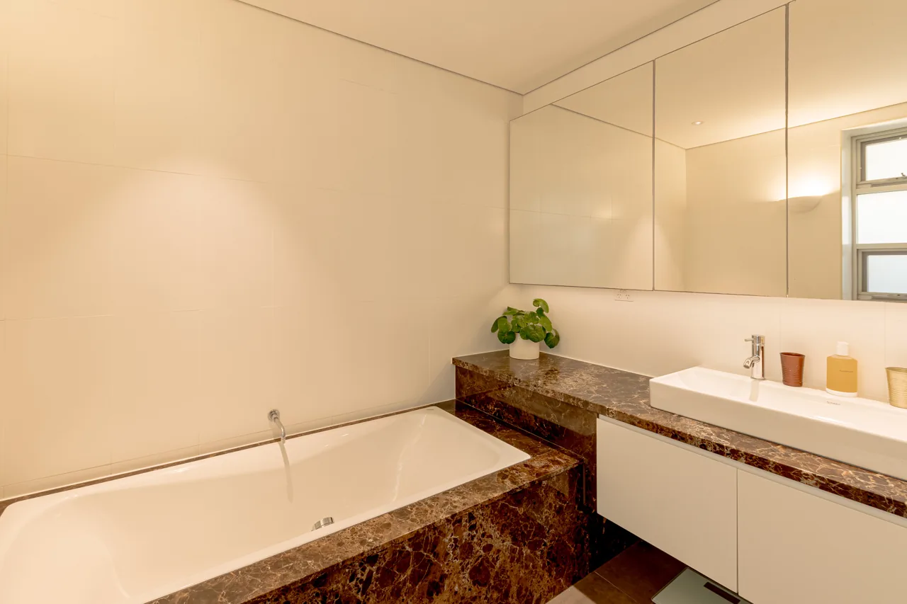 Bathroom with bathtub, glass shower screen and stone vanity