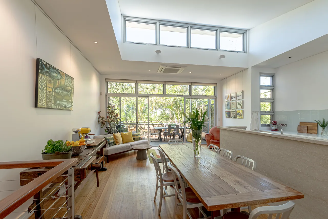 Open-plan dining room with timber table and clerestory windows